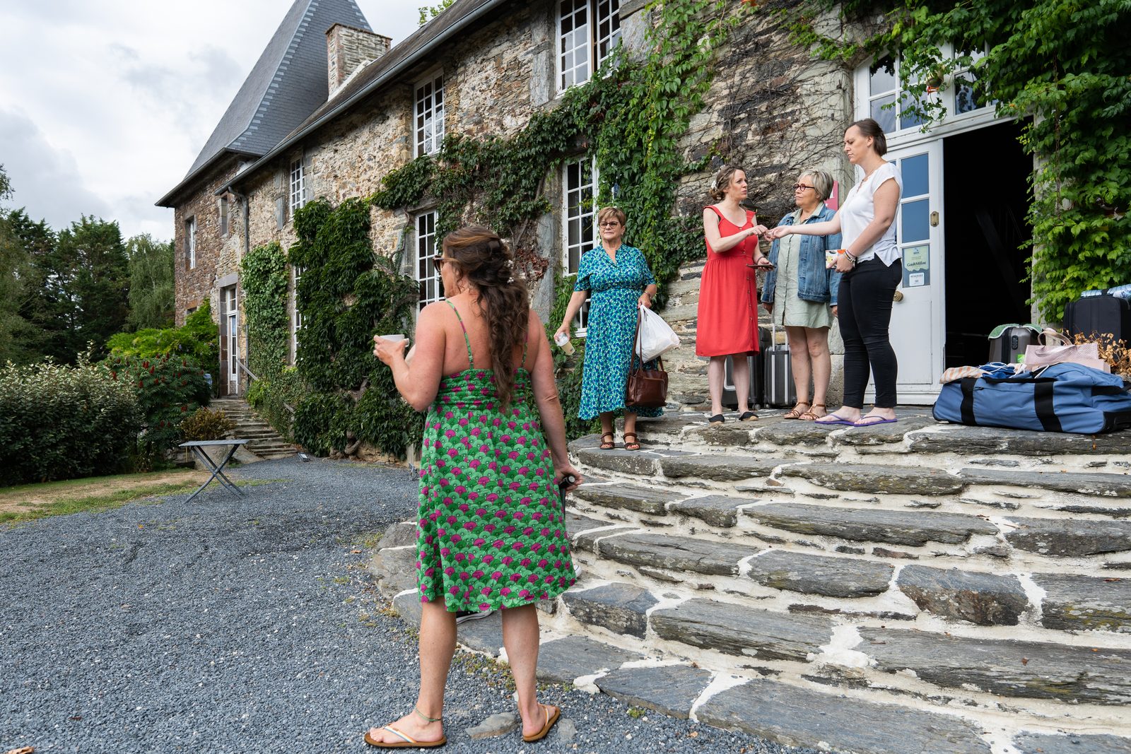 Les invités arrivent sur le perron de pierre couvert de lierre — mariage au Château de la Roque — Arnaud Chapelle