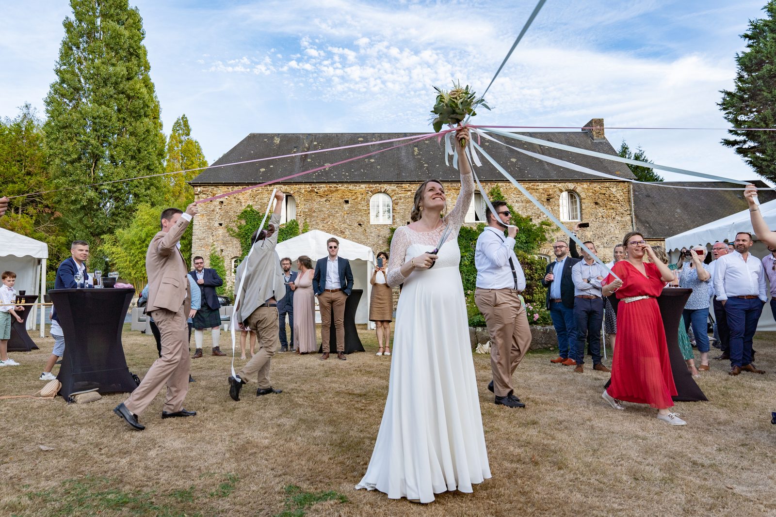 Le bouquet s'envole pendant le vin d'honneur, devant le château — mariage au Château de la Roque, Théreval — Arnaud Chapelle