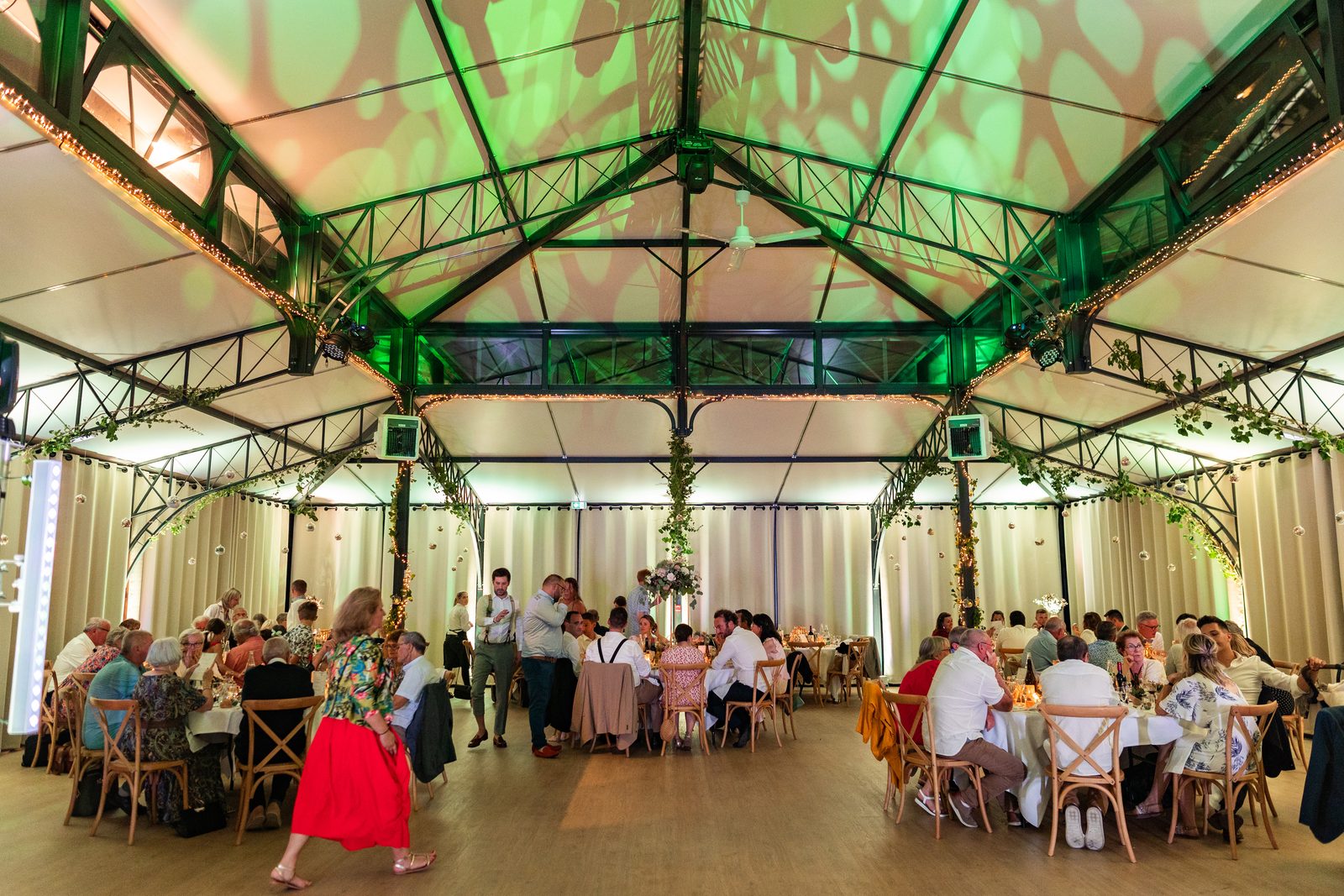 Les invités à table sous la verrière de L'Orangerie — mariage au Château de la Roque — Arnaud Chapelle