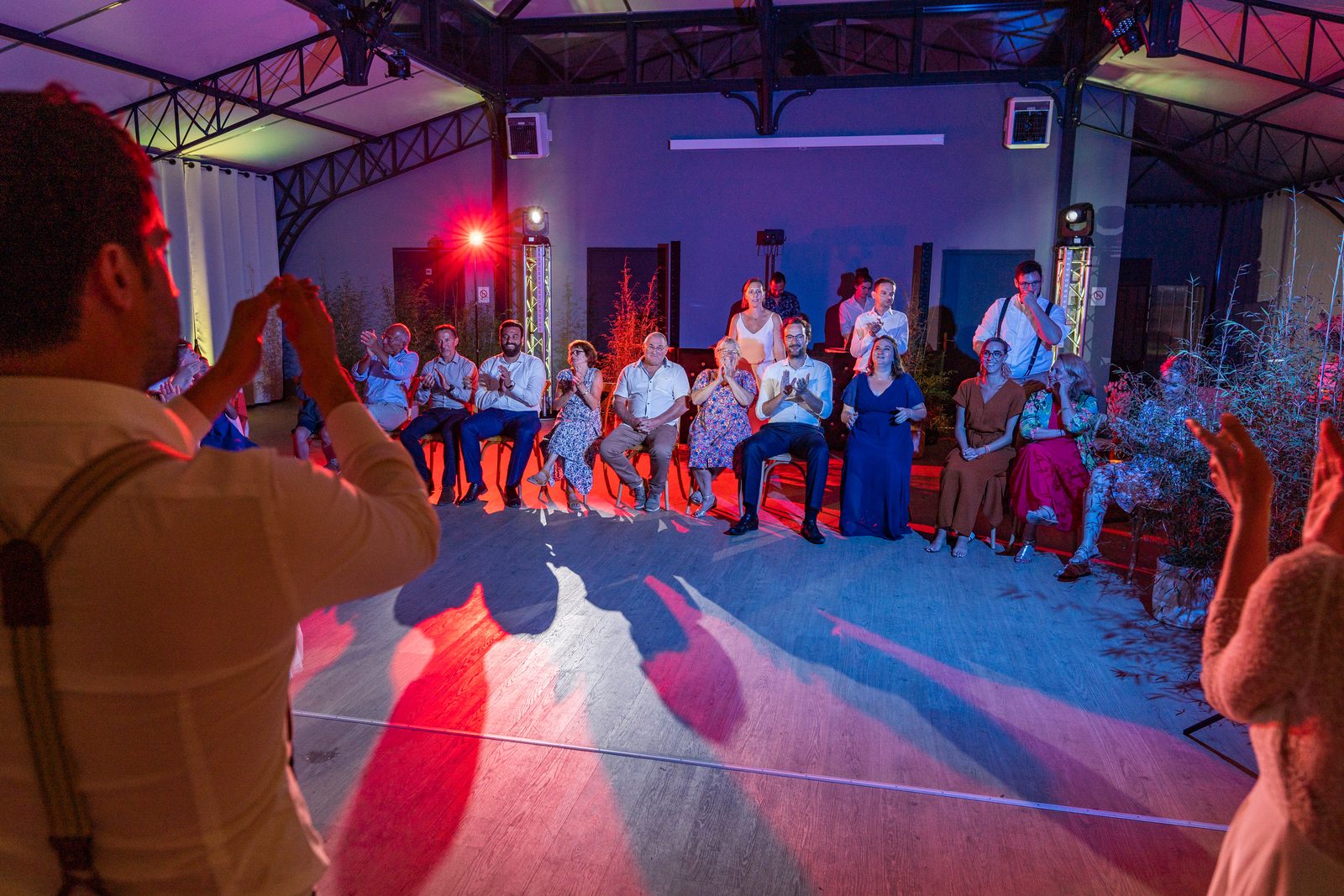 Les invités en cercle autour de la piste, lumières rouges et bleues — soirée au Château de la Roque — Arnaud Chapelle