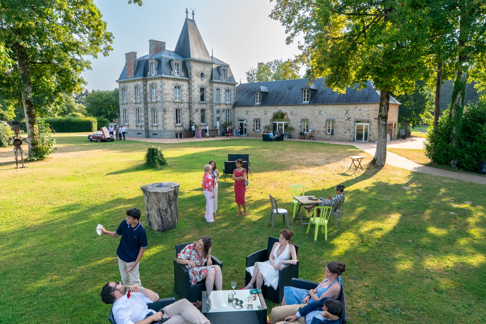 Les invités dans le parc devant le château du XIXᵉ et la salle de pierre — mariage aux Châteaux de La Lucerne d'Outremer — Arnaud Chapelle