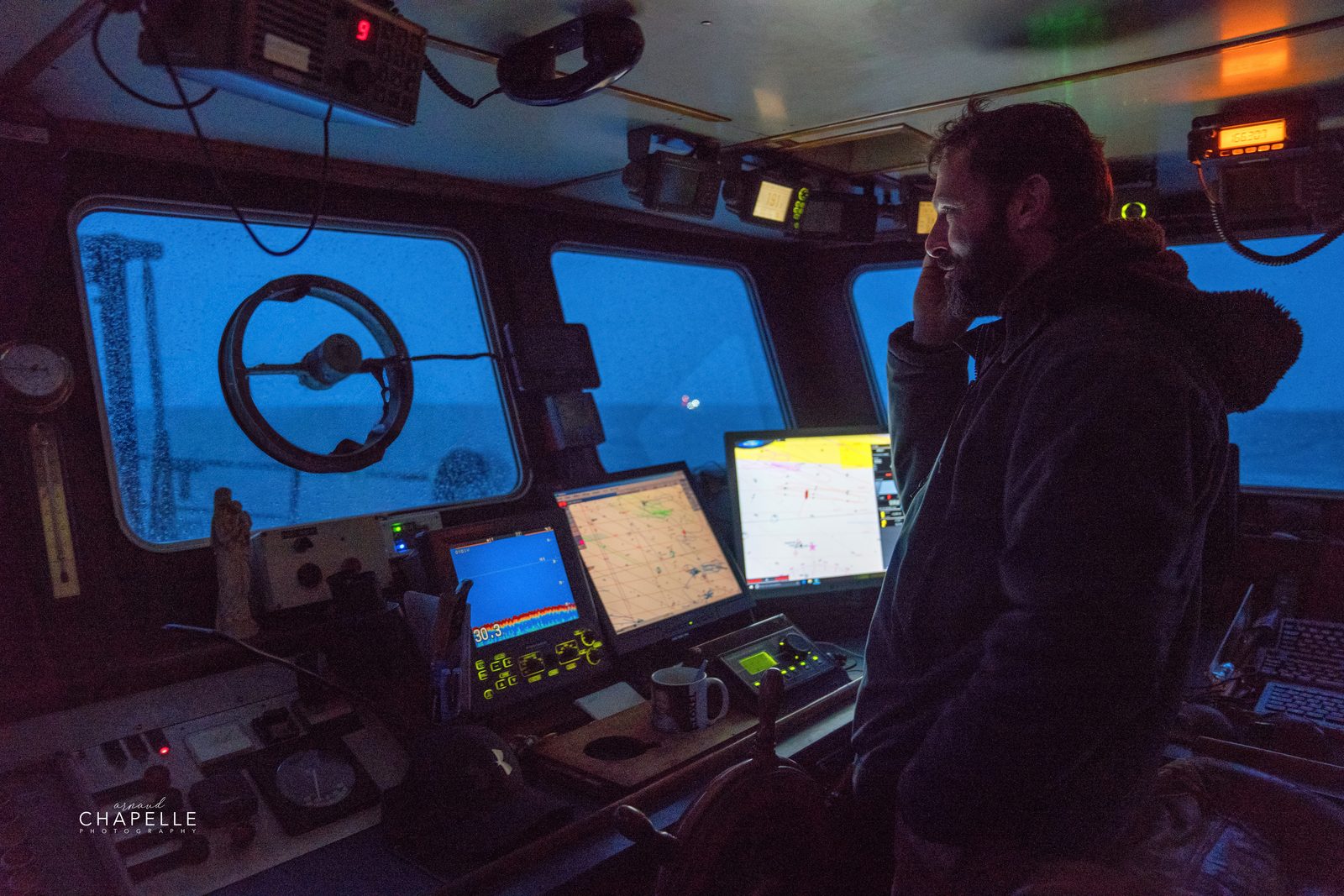La cabine de pilotage du Télémaque dans la nuit, écrans et radars allumés — Arnaud Chapelle