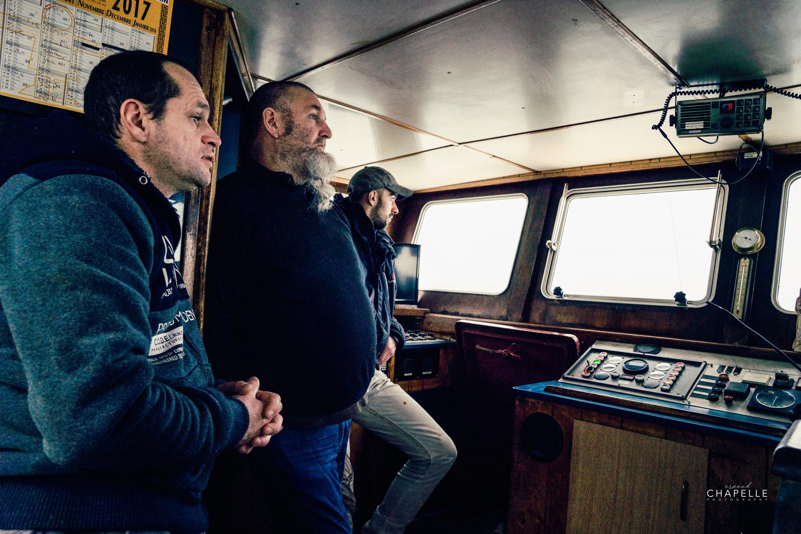 Trois hommes dans la cabine de pilotage du Télémaque, le regard vers la mer — Arnaud Chapelle