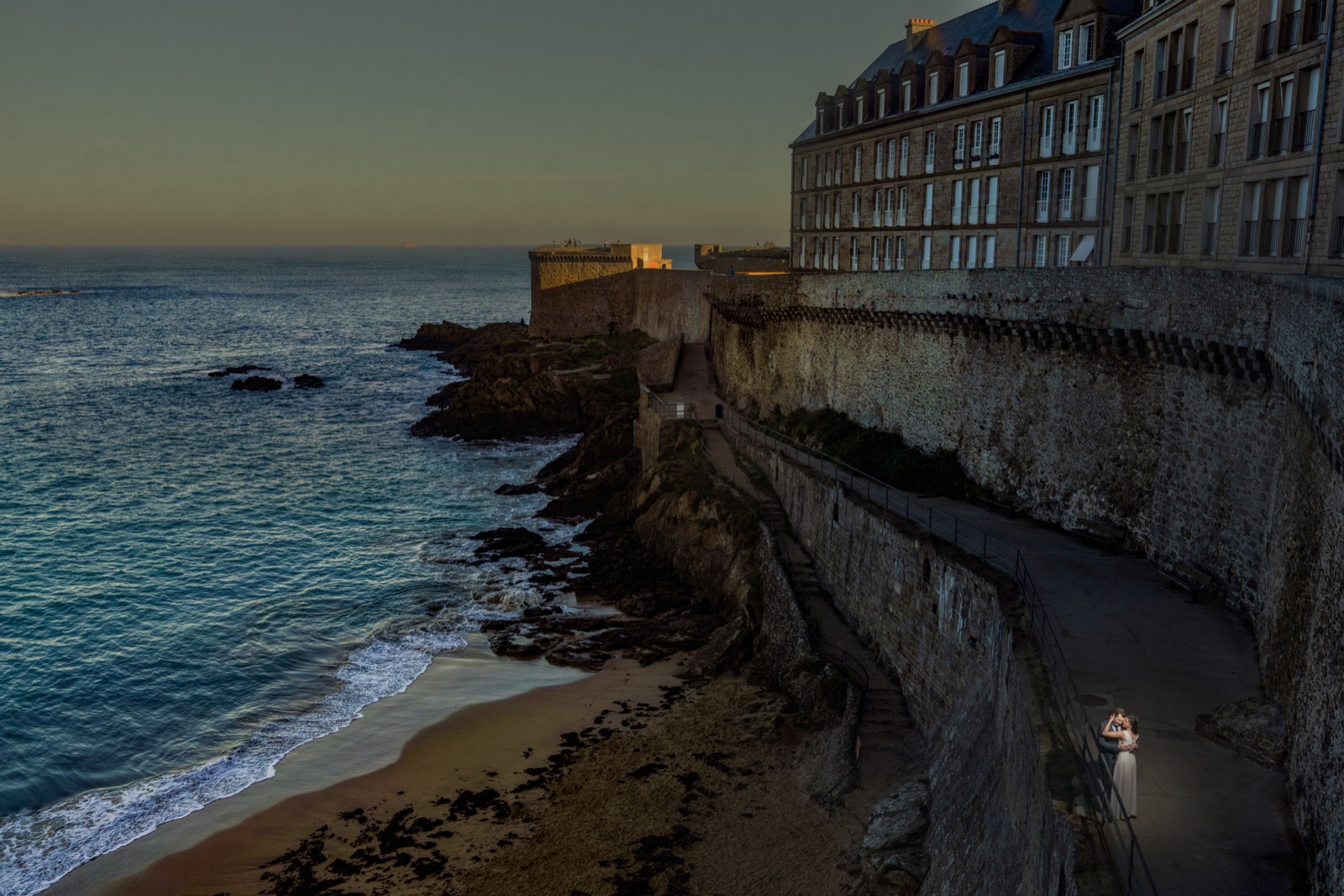 Marine en robe de mariée sur le chemin de ronde des remparts de Saint-Malo au crépuscule