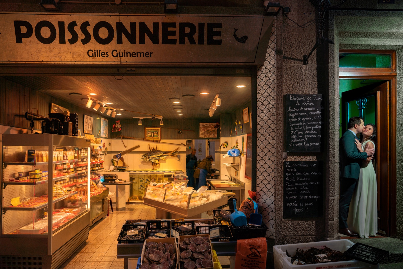 Marine et Alexandre s'embrassent sur le pas de porte voisin de la poissonnerie éclairée — Saint-Malo intra-muros le soir — Arnaud Chapelle