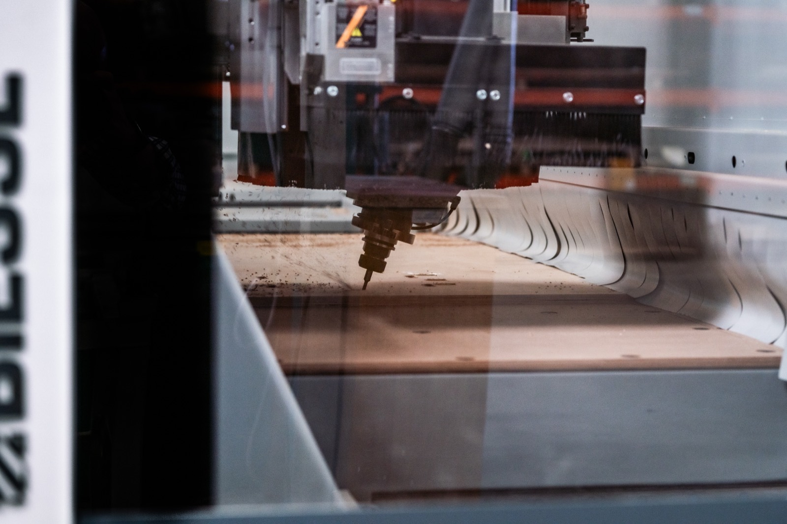 Gros plan sur la fraise de la machine à commande numérique qui usine le panneau — reportage photo industriel en Normandie — Arnaud Chapelle