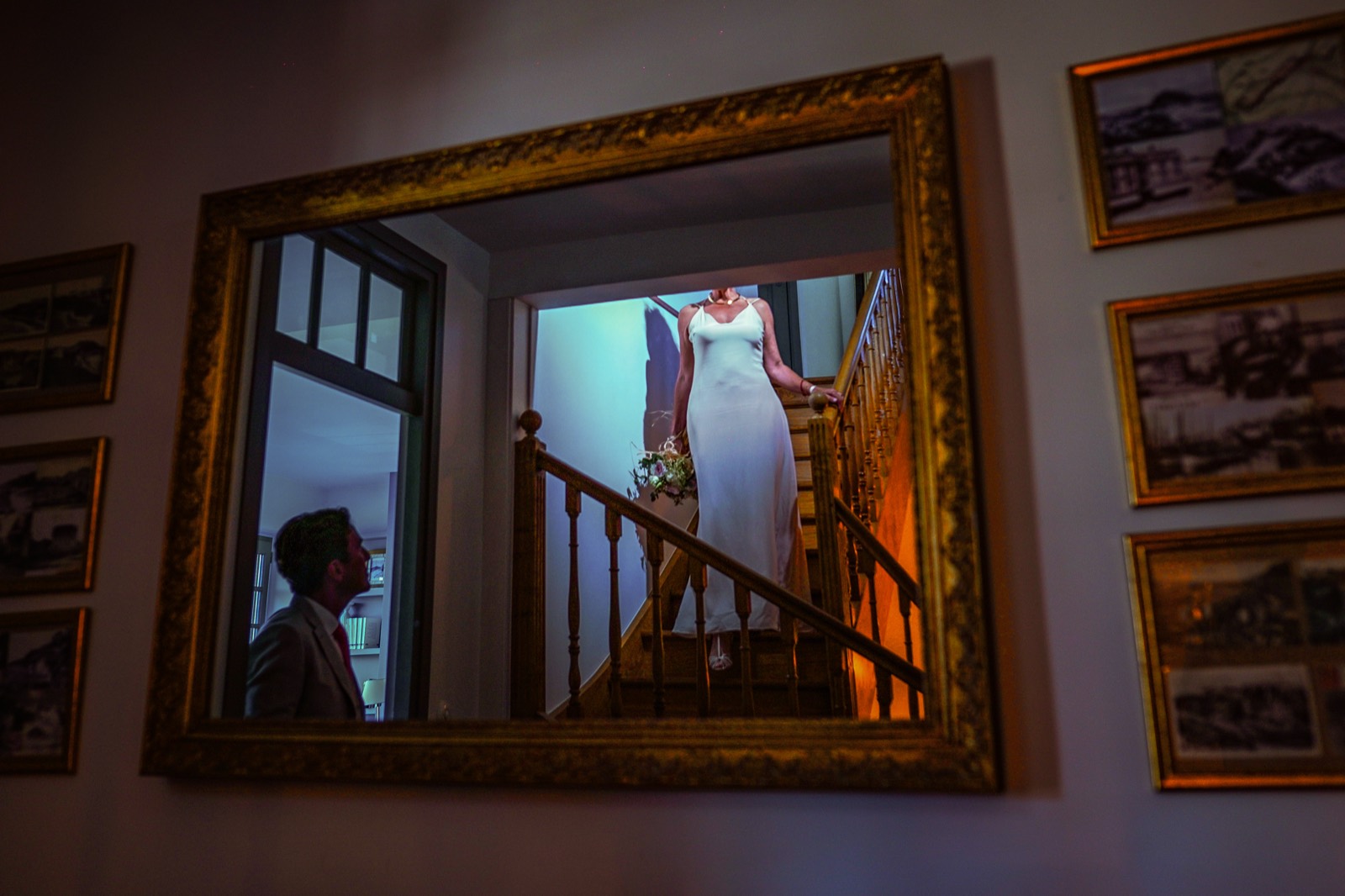 La mariée dans l'escalier du château, aperçue dans le reflet d'un miroir doré — séance couple after-wedding, Granville — Arnaud Chapelle