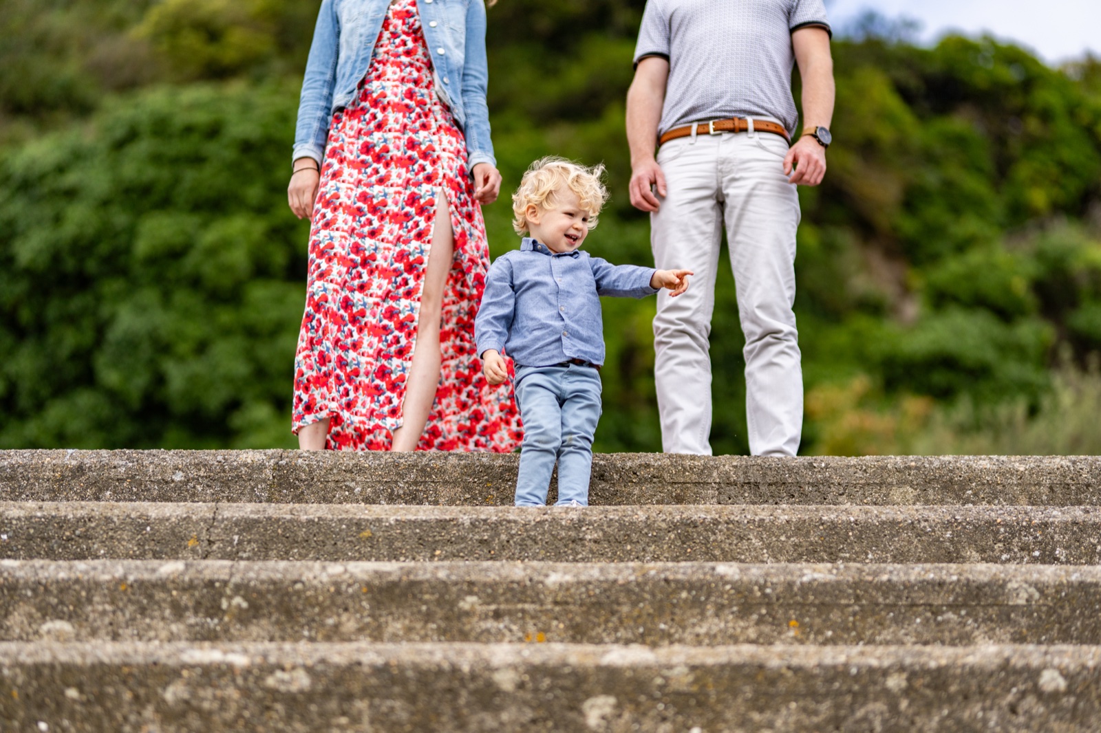 Le petit garçon descend les marches entre ses parents — séance famille à Cancale — Arnaud Chapelle