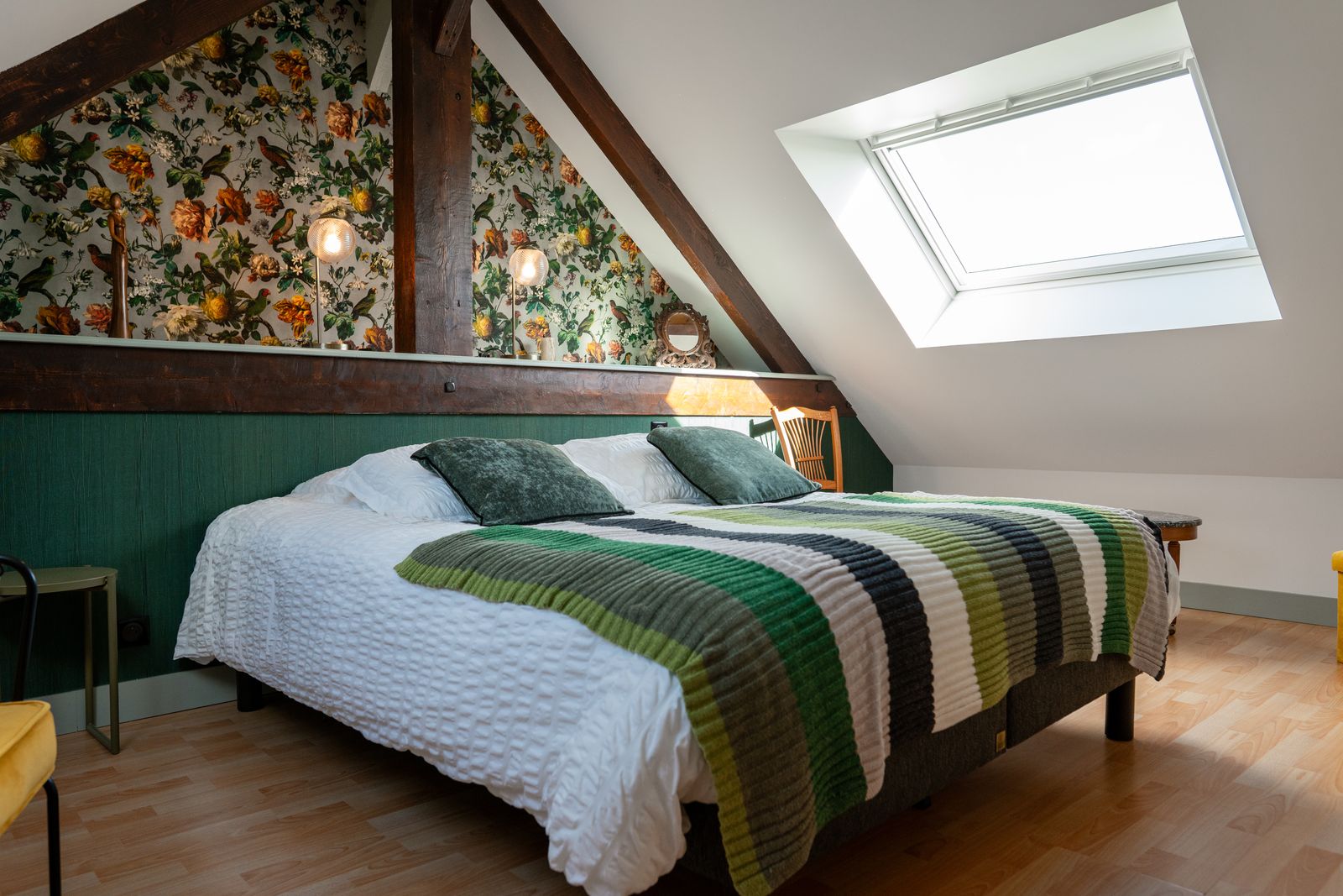Bedroom under exposed beams, floral wallpaper