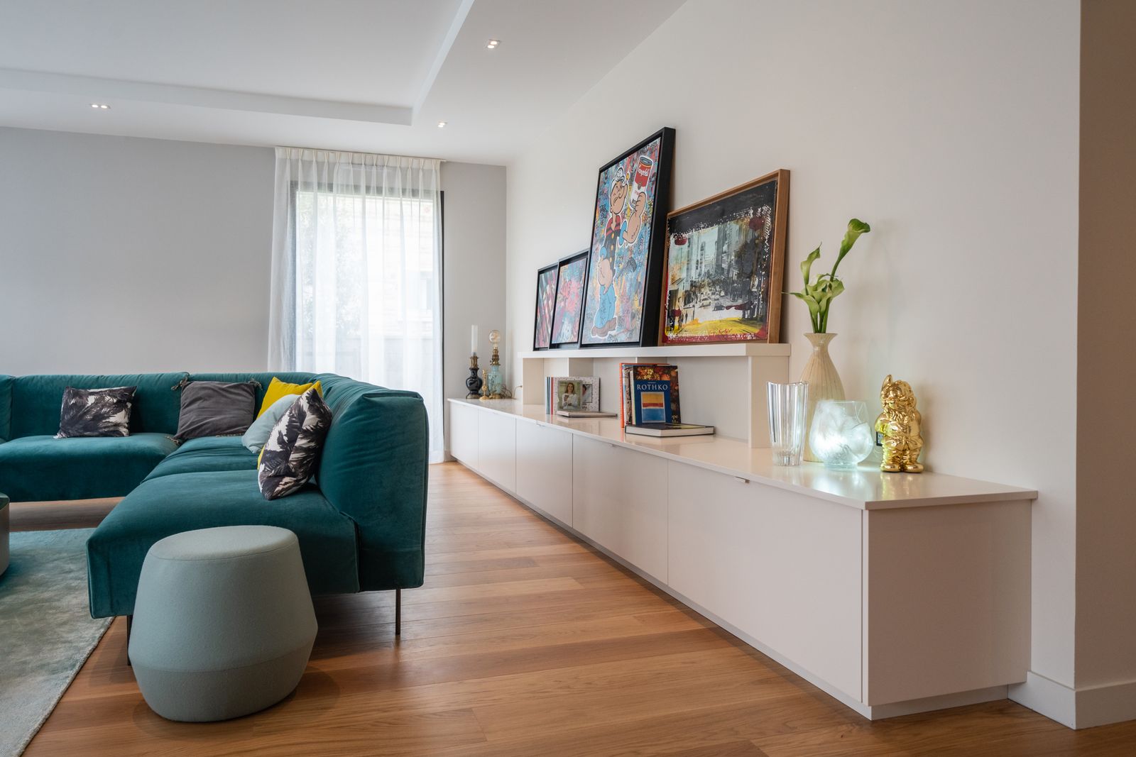 Bright living room, long white unit and paintings