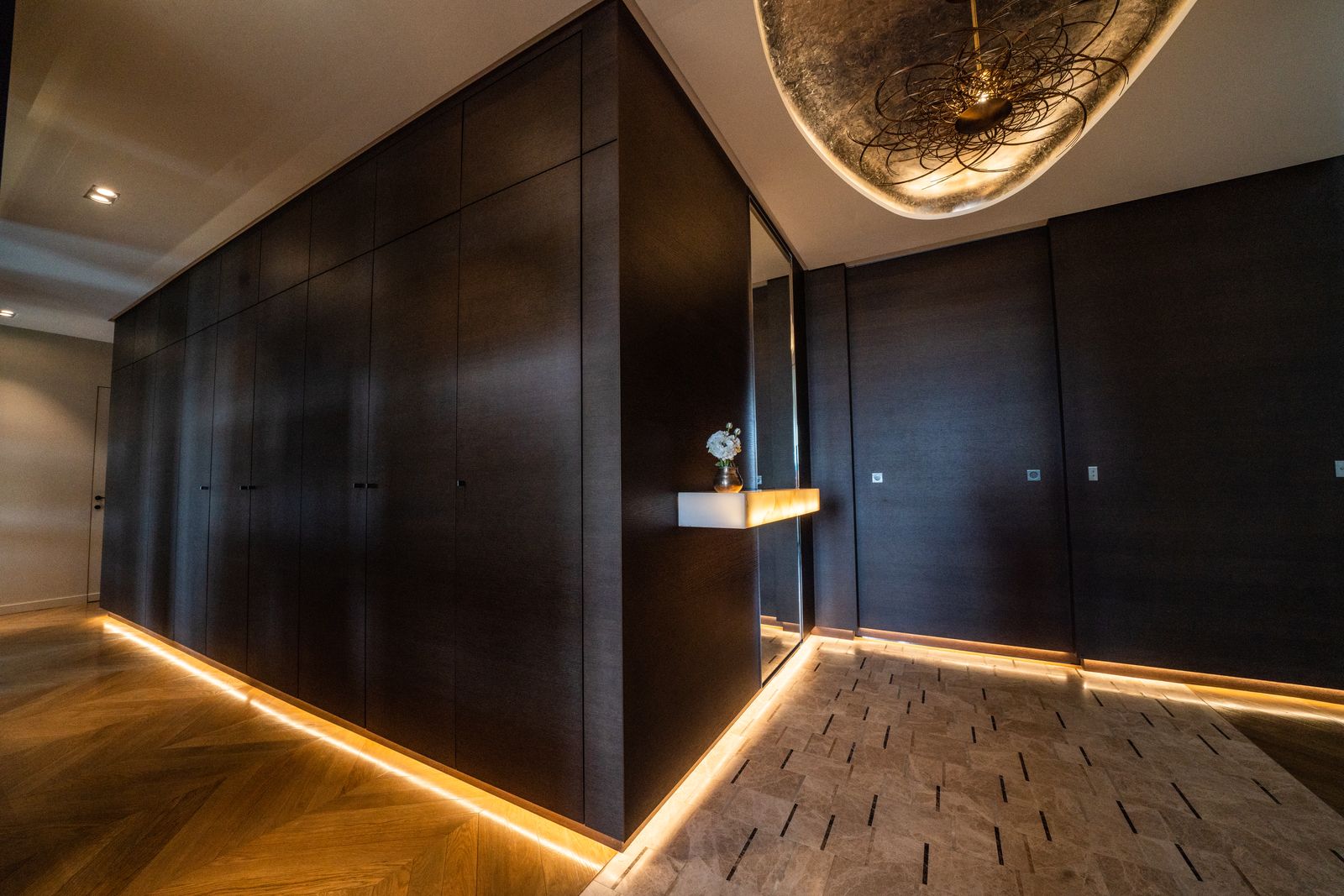Apartment hallway, dark joinery and indirect lighting