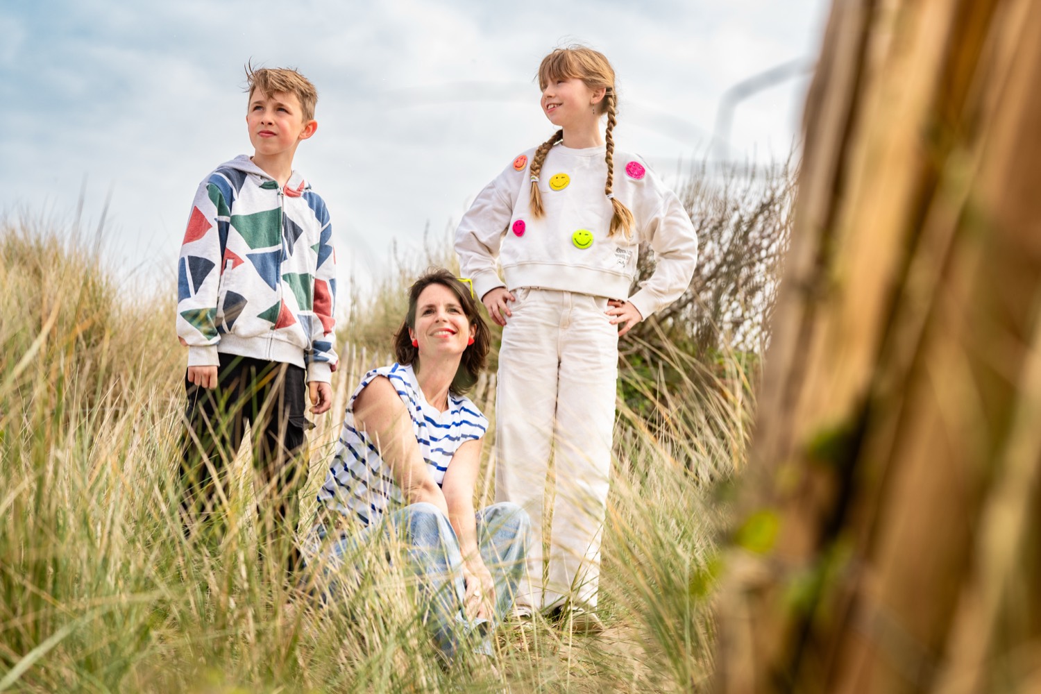 A mother and her two children among the marram grass of the Normandy dunes