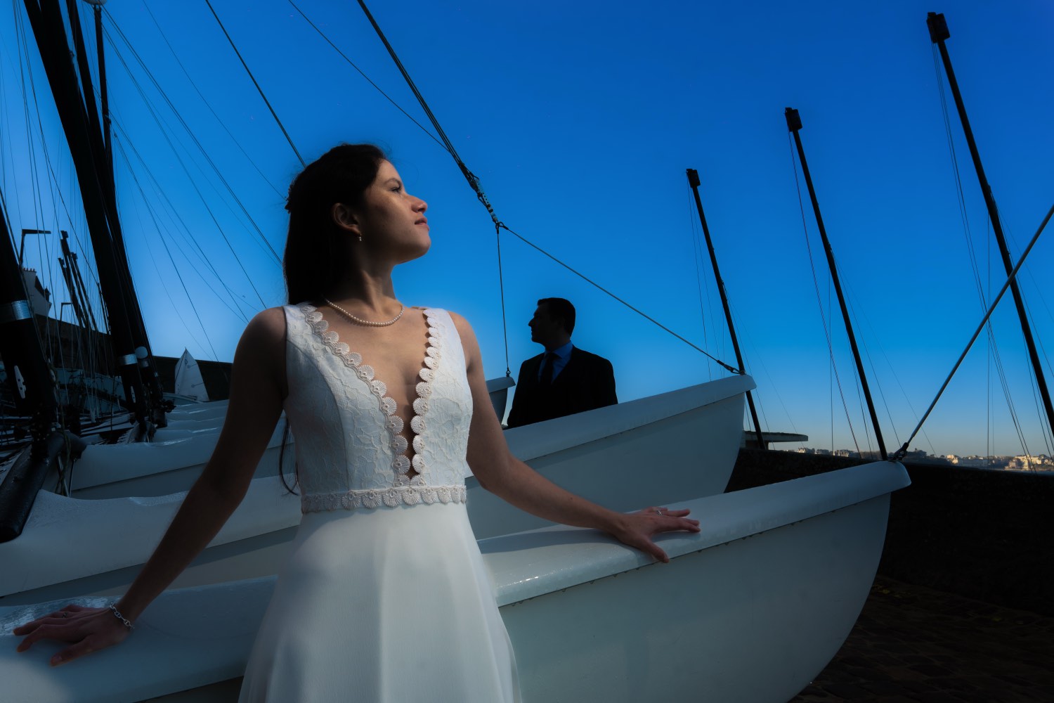 Bride and groom among sailing boats on the Normandy coast