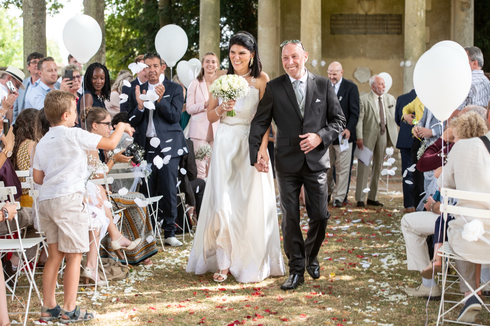Sortie de cérémonie sous les pétales et les ballons — mariage au Château de Canon, Mézidon (Calvados) — Arnaud Chapelle
