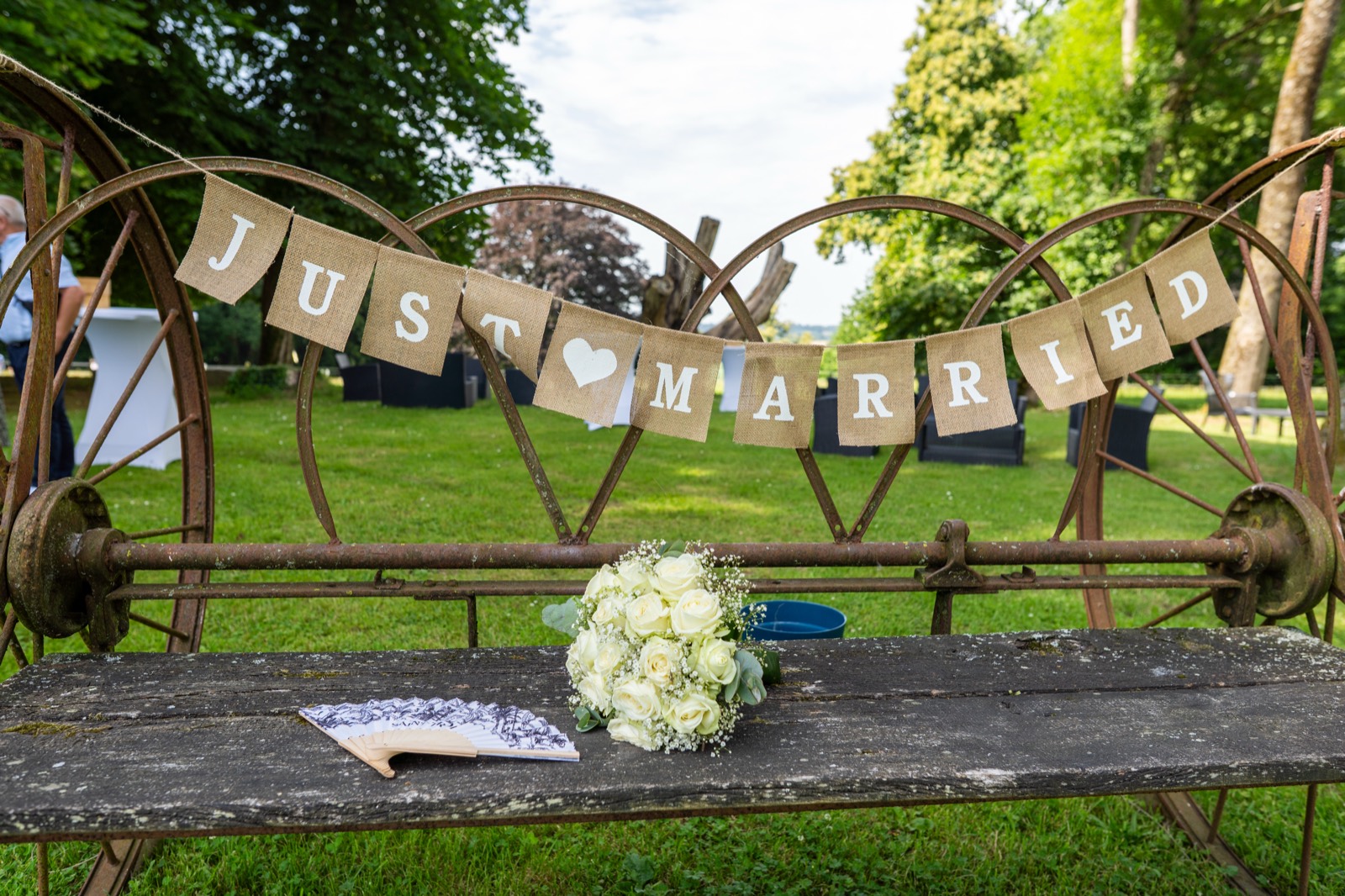 Banderole « Just Married » et bouquet de la mariée sur un banc ancien — mariage à La Lucerne-d'Outremer (Manche) — Arnaud Chapelle