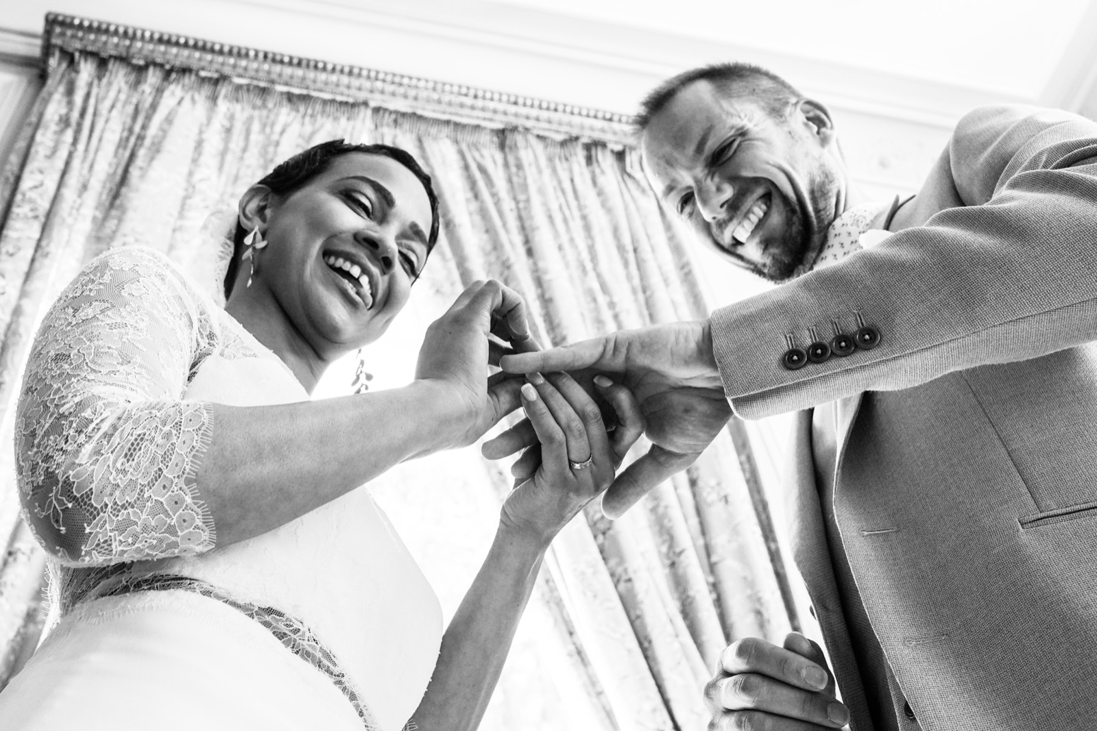Échange des alliances, les mariés rient, en noir et blanc — mariage au Château du Perron, près de Saint-Lô — Arnaud Chapelle