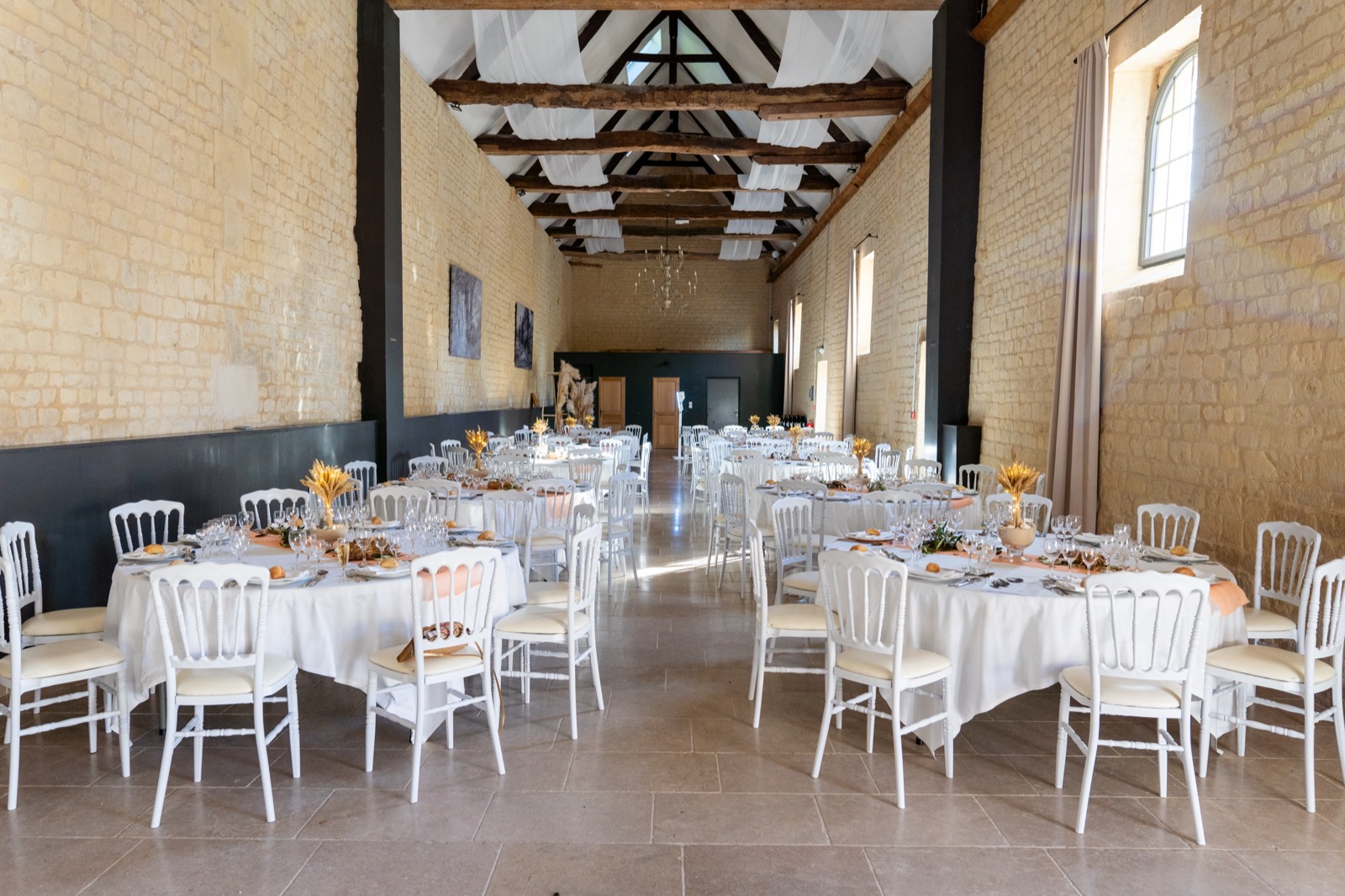 Salle de réception aux vieilles pierres dressée pour le dîner — Domaine de la Cour des Lys — Arnaud Chapelle
