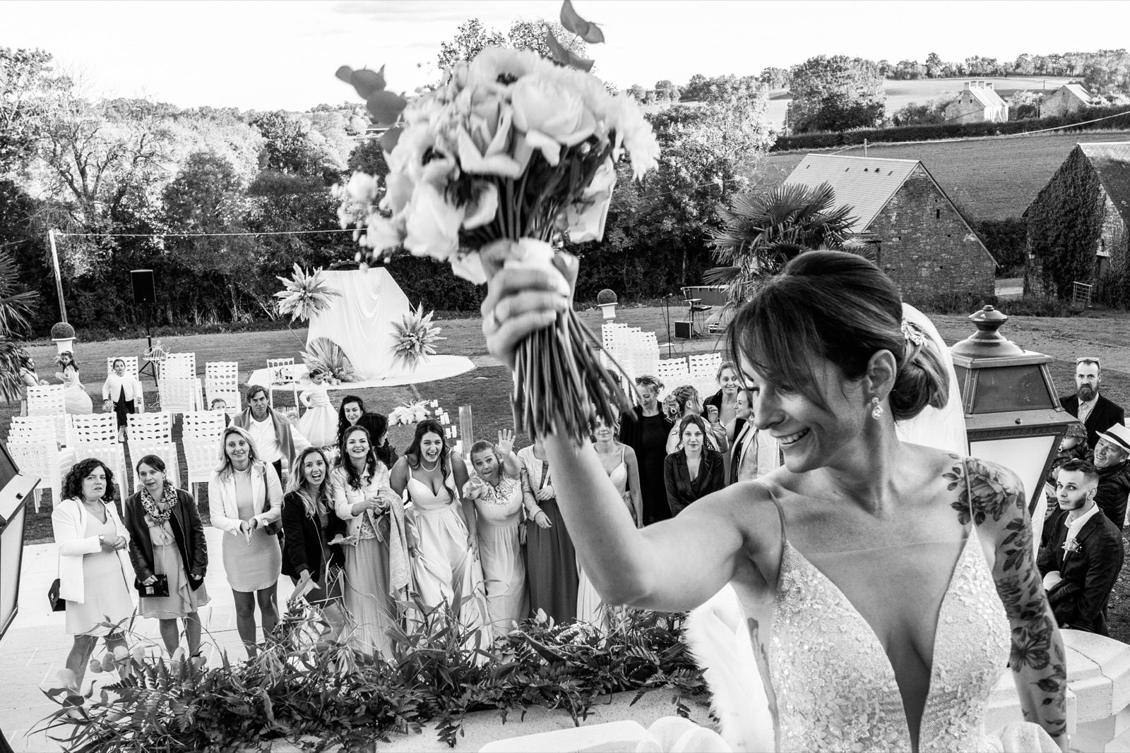 Le lancer du bouquet, vue sur la vallée normande — mariage au Domaine d'Aslan, près de Caen — Arnaud Chapelle
