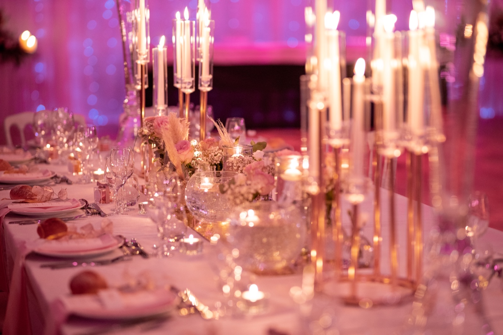 La table de réception à la lueur des bougies dans l'orangerie — soirée au Domaine d'Aslan, Préaux-Bocage — Arnaud Chapelle