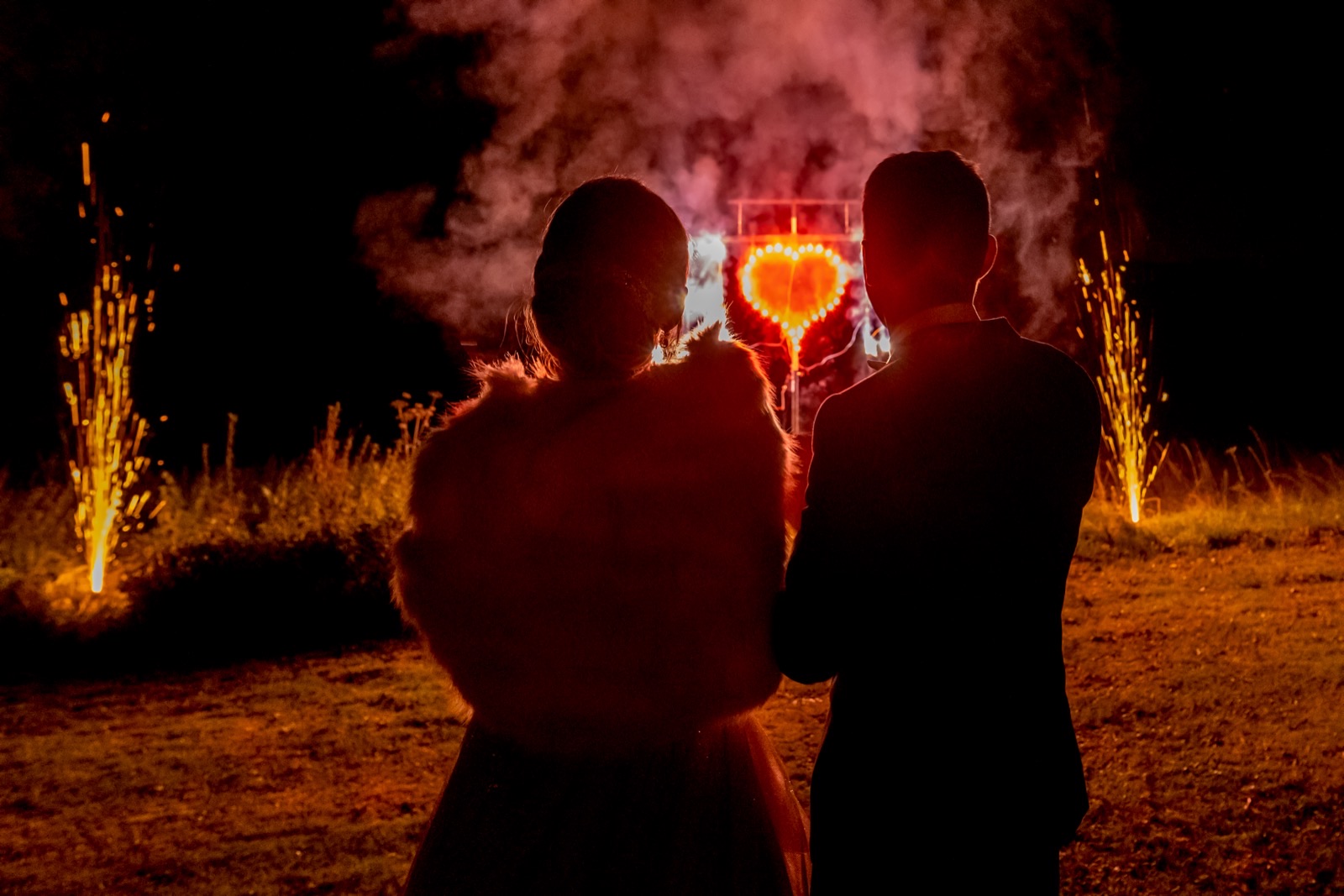 Les mariés en silhouette devant un cœur enflammé, en soirée — Domaine d'Aslan, près de Caen — Arnaud Chapelle