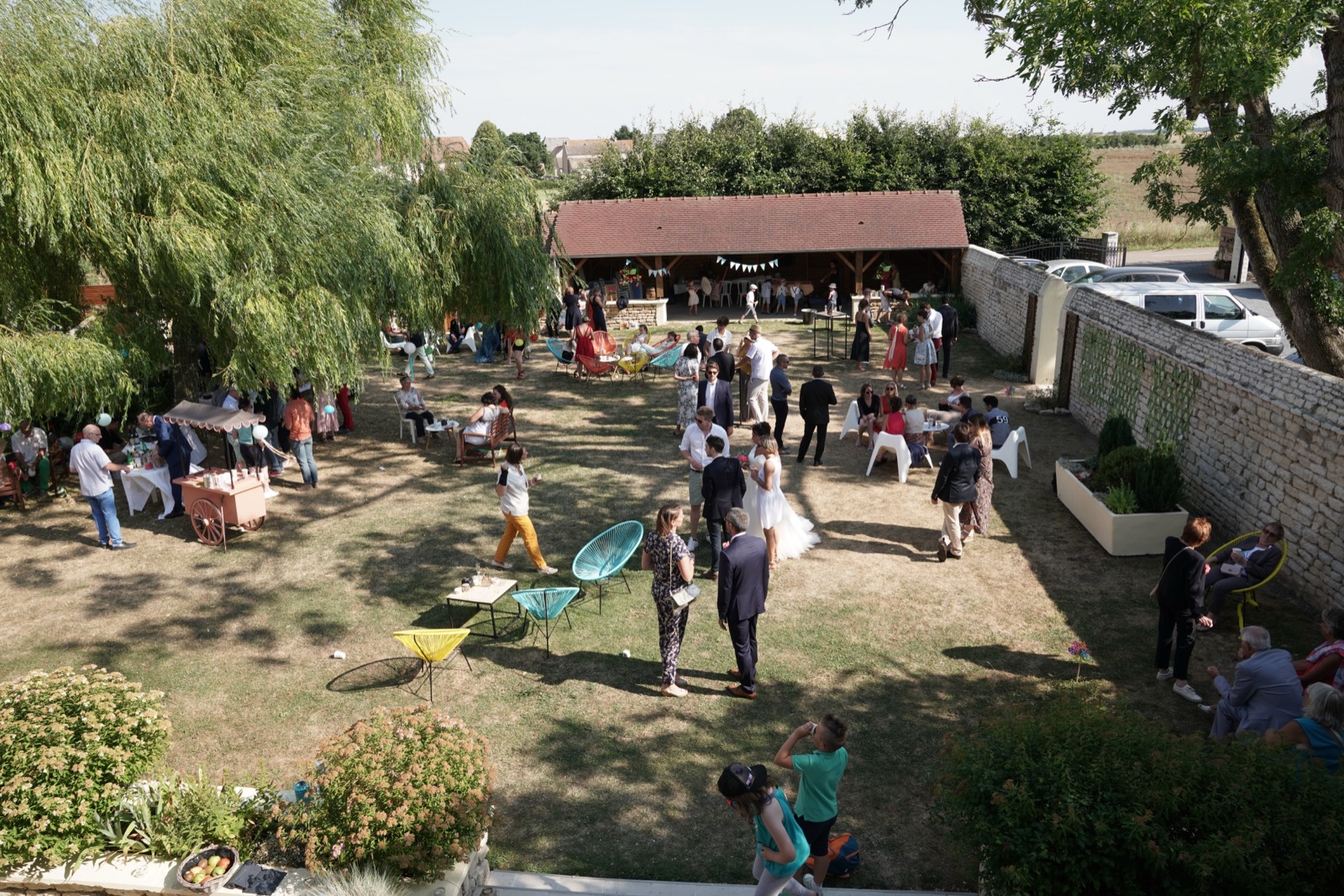 Le vin d'honneur dans le jardin du Domaine de Cauvicourt, devant la grange de pierre — lieu de mariage à Cauvicourt, entre Caen et Falaise (Calvados) — Arnaud Chapelle