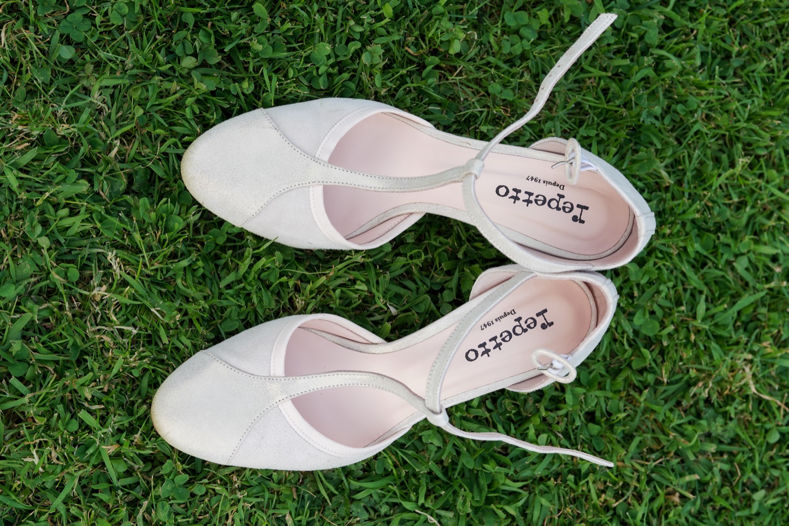 Détail : chaussures de la mariée dans l'herbe — mariage au Domaine de Cussy, Bessin — Arnaud Chapelle