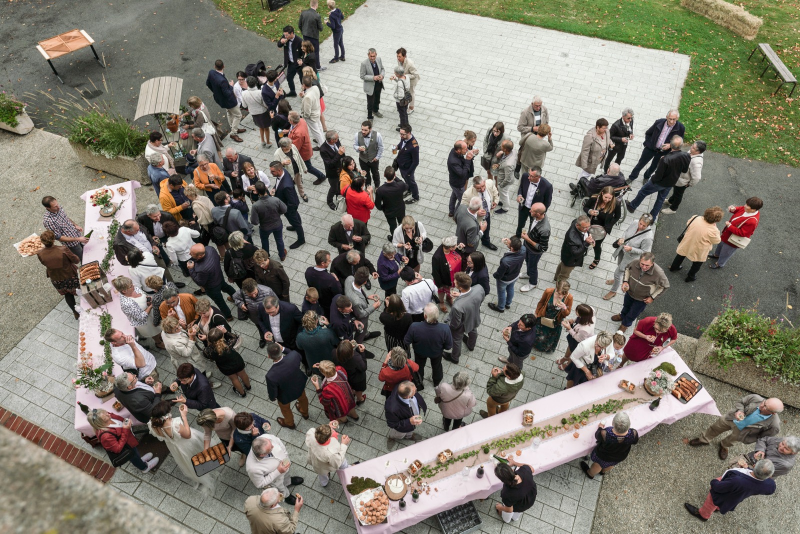 Le vin d'honneur dans la cour, vu d'en haut, invités et grandes tables — mariage au Domaine de Pont-Ramond, près de Flers — Arnaud Chapelle