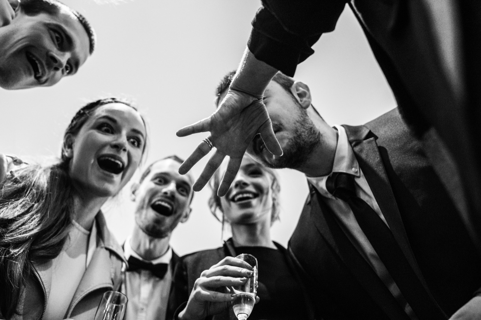 Invités qui trinquent au vin d'honneur, en noir et blanc — mariage au Domaine du Grand Caugy (Calvados) — Arnaud Chapelle