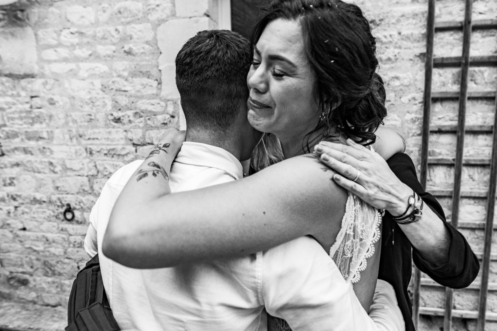 Étreinte émue contre la pierre — mariage au Domaine du Saul', Louvigny (Calvados) — Arnaud Chapelle