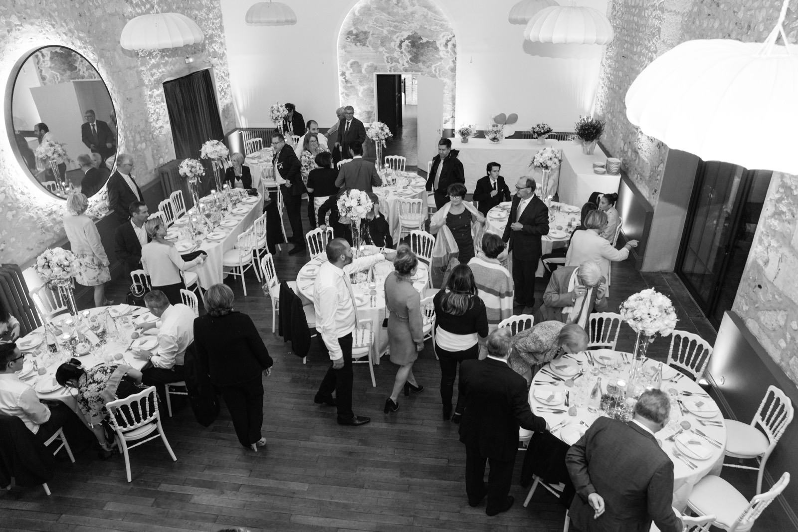 La salle de réception et son grand miroir rond, murs de pierre — mariage à La Dîme de Giverny, Giverny — Arnaud Chapelle