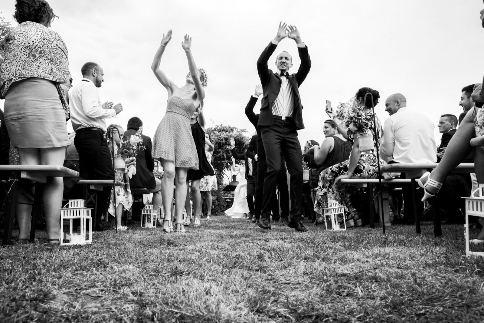 Un invité danse dans l'allée pendant la cérémonie, en noir et blanc — mariage au Manoir de Chivré, entre Bayeux et Saint-Lô — Arnaud Chapelle